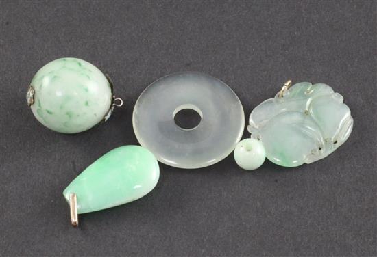 A group of four Chinese jadeite pendants or beads and a similar hardstone disc, late 19th/20th century, largest 3.3cm